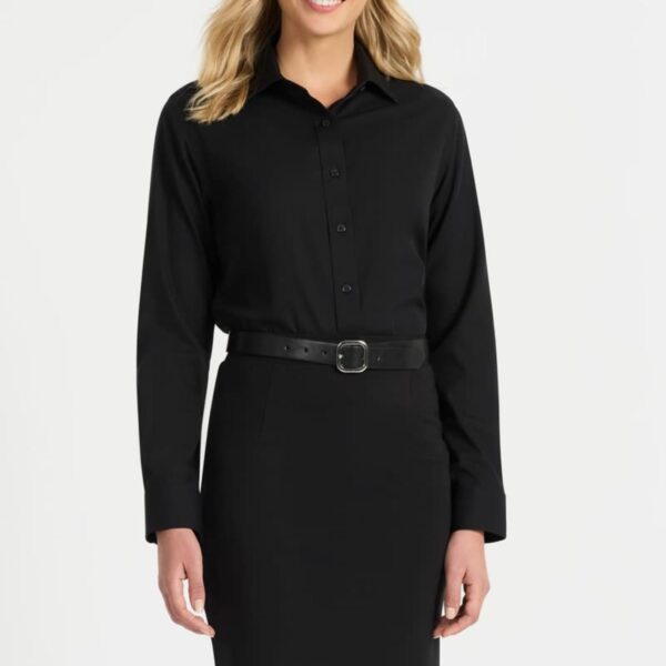 A person with shoulder-length blonde hair is smiling while wearing a black button-down dress with a belt. The background is plain white.