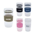 Image of five transparent reusable cups with lids and differently colored silicone grips. Each cup has a different brand logo: Etnies (olive), Koss (black), Prada (dark blue), Zavetti (pink), and Oasis (light blue).