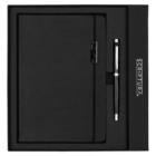 A black leather-bound notebook and a matching black pen are elegantly presented in a black gift box. The box features the brand name SCRIPTURA on the side.
