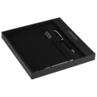 A black leather notebook and pen set is displayed in a sleek black presentation box. The notebook has a metallic clasp, and the set exudes a sophisticated and professional look.