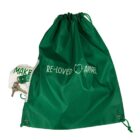 Green drawstring bag labeled RE-LOVED APPAREL with keys and a white pouch partly visible.