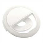 Round white selfie ring light with a clip-on design, featuring a central circular opening and an array of small LED lights around the inner edge.