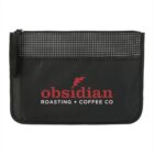 A black zippered pouch featuring a grid pattern on the top section and the words obsidian ROASTING + COFFEE CO in red and white text on the front.