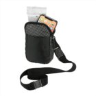 A small black crossbody bag with a grid pattern on the front pocket, holding a smartphone and a packet. It has an adjustable strap with a buckle.