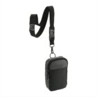 A small, black crossbody bag with a grid pattern on the front. It has a rectangular shape and is attached to a detachable black strap with a plastic buckle and clip.