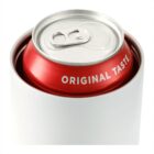 A close-up of a red soda can with the words ORIGINAL TASTE partially visible, placed inside a white container. The can is unopened, and the metallic top with the pull tab is in focus.