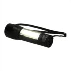 A black flashlight with a wrist strap. It has a cylindrical body with a transparent middle section showing the light inside. The flashlight is standing upright against a plain white background.