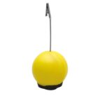A bright yellow spherical object with a smooth surface, attached to a black base. A thin metal cable extends from the top, ending in a silver clip. The object appears to be designed for hanging or securing.