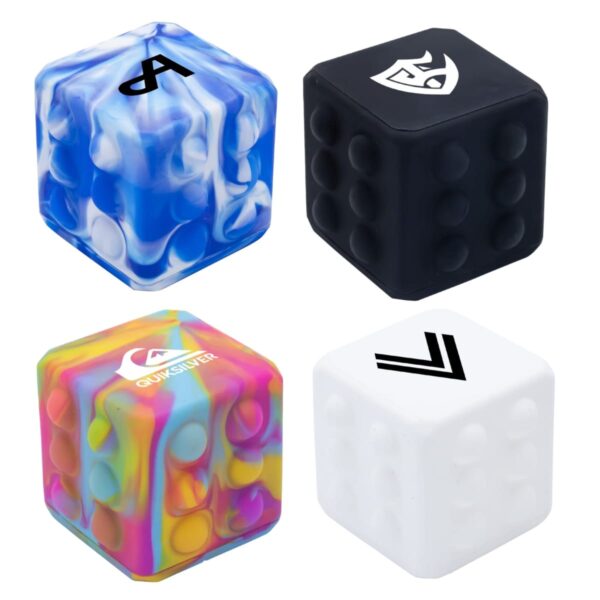 Four colorful, textured cubes, each with a unique design: a blue and white marbled cube with an A, a solid black cube with a logo, a multi-colored cube with Quiksilver, and a plain white cube with an arrow symbol.