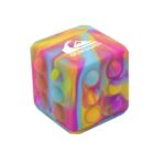 A colorful, cube-shaped stress-relief toy featuring a mix of pink, yellow, blue, and green swirls. The Quiksilver logo is printed in white on top. The cube has a textured surface with circular indentations.