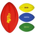 Four foam rugby balls in different colors: a red ball with accu-grafix in yellow, a yellow ball with M&Ms in brown, a blue ball with NORTEL in white, and a green ball with Baldwin in white.