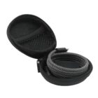 A small round black case is open, revealing a coiled black and white braided cable inside. The case has a mesh pocket on the left side. The cable appears to be for electronic devices.