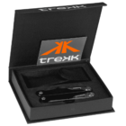 A sleek black multitool rests in an open black box with trekK branding on the lid. The box includes a black carrying pouch, all set within foam inserts for protection.