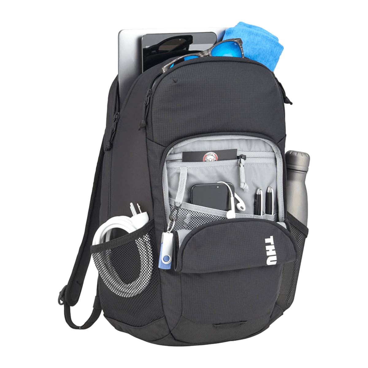A black backpack with multiple compartments, featuring items like a laptop, blue towel, sunglasses, water bottle, cables, pens, and a smartphone. The front pocket has the letters THU on it.