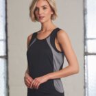 Woman wearing a black and gray sleeveless athletic top stands indoors near windows.