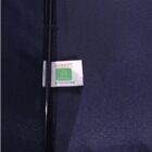 Close-up of a dark-colored umbrella with a tag that reads NI CONCEPT and RECYCLED MATERIALS alongside a recycling symbol. The website www.niconcept.com.au is also visible on the tag.