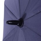 Close-up of a blue umbrella, focusing on the tip and fabric. The black tip protrudes from the center, and radiating lines form triangular segments across the surface, showing the texture and weave of the umbrella.
