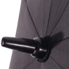 Close-up of a black umbrella tip. The fabric is stretched tightly over the frame, and the glossy, rounded handle end is prominently visible. The texture and stitching of the umbrella are clearly detailed.