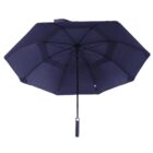 A blue umbrella is open, revealing its underside with metal ribs and a central pole. The handle is visible at the bottom. The umbrella is photographed against a white background.