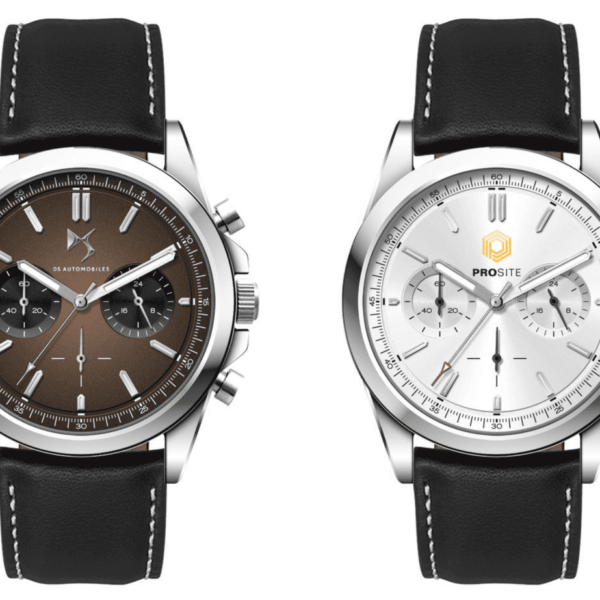 Two wristwatches with black leather straps. The left watch has a brown face with black sub-dials and silver markers. The right watch features a white face with silver sub-dials and a yellow logo at the top. Both have silver bezels.