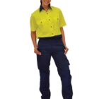 Woman wearing a yellow high-visibility shirt and navy work pants, smiling and standing.