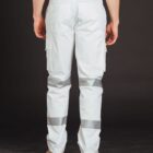 A person wearing white cargo pants with reflective stripes and tan work boots is standing with their back facing the camera against a dark background.