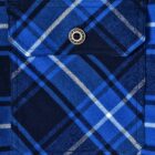 Close-up of a blue and black plaid fabric with a pocket. The pocket features white and navy lines in a checkered pattern, a flap, and a silver button.