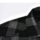 Close-up of a black and gray plaid shirt collar on a white background.