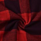 Close-up of red and black plaid fabric with a central swirl pattern, showcasing the checkered design and texture.