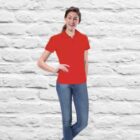 Wearing a Velocity Ladies Polo with blue jeans, a person leans against a white brick wall with casual confidence. A smile highlights their effortless style and charm as one hand rests on their hip.