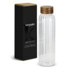 Clear ribbed glass bottle with a wooden lid next to a black box labeled keepsake.