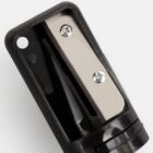 Close-up of a black and silver pencil sharpener on a white background.