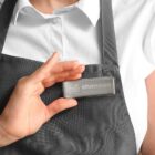 Person in gray apron holding a name tag that reads shannon, manager on their chest.