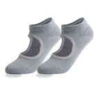 A pair of light grey, low-cut yoga socks with open tops and non-slip grips on the soles. The socks are shown side by side against a white background.