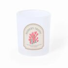 White candle with a Modern Tropic label featuring pink flowers and green leaves.