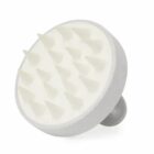 White silicone scalp massager with soft, pointed bristles and a rounded handle.