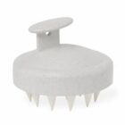 White scalp massager brush with a handle and pointed bristles, shown on a plain background.