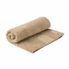 A rolled-up beige bath towel placed on a flat surface.