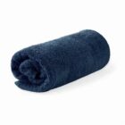 Rolled up dark blue towel on a white background.