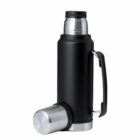 Black thermos flask with a handle and a silver cup placed on its side.