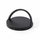 Black circular wireless charger with an arched handle and a USB-C port on the side.