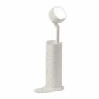 White ergonomic toothbrush standing in a matching holder shaped like a boot.