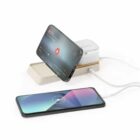 Two smartphones charging, one upright as a stand and one lying flat, connected by white cables.