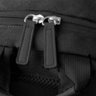 Close-up of two black zipper pulls on a textured black bag.