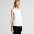 Woman in a sleeveless white top and black pants stands against a plain light background.
