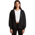 Woman wearing a black zip-up hoodie over a white crop top and black pants, facing forward.