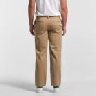 Man in khaki pants and white t-shirt standing with back facing the camera.