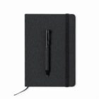 A black pen rests on top of a closed black notebook with an elastic band and ribbon bookmark.
