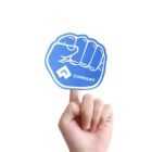 A hand is holding up a blue foam finger shaped like a fist. The foam finger has a logo resembling an upward arrow, followed by the word COMPANY. The background is plain white.