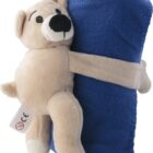 The beige Cuddle Buddy Bear with Blanket features a stitched arms embrace of a rolled-up blue fleece blanket. Its charming smile and the small tag on its leg with a CE mark ensure quality and safety.